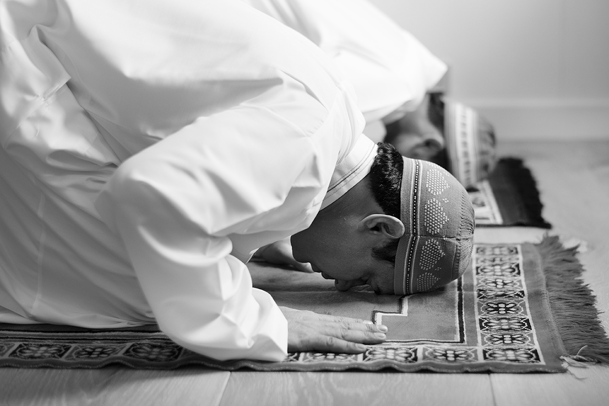 الوسواس القهري عند لأطفال- Two men praying on a rug.