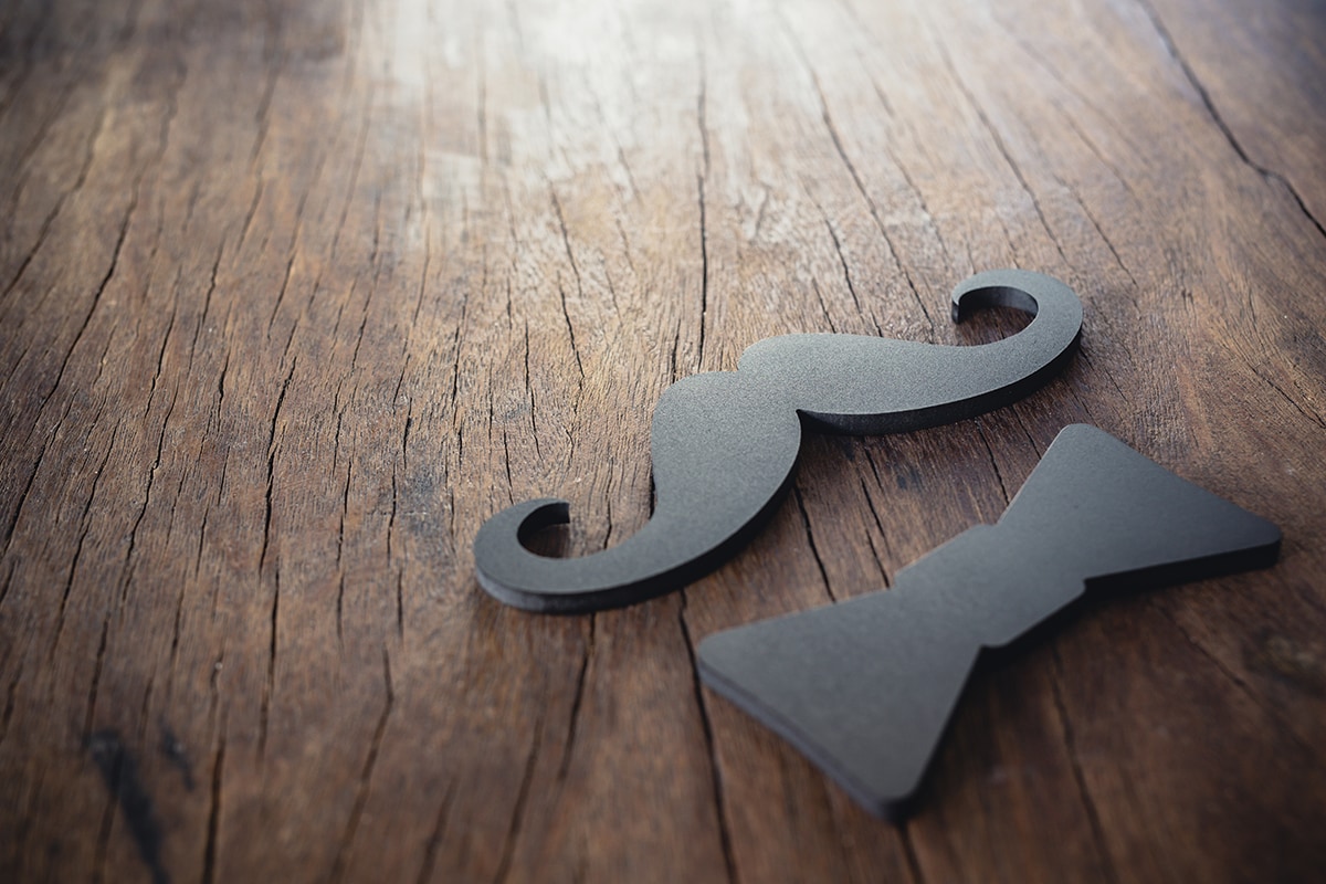 A black mustache on a wooden table.