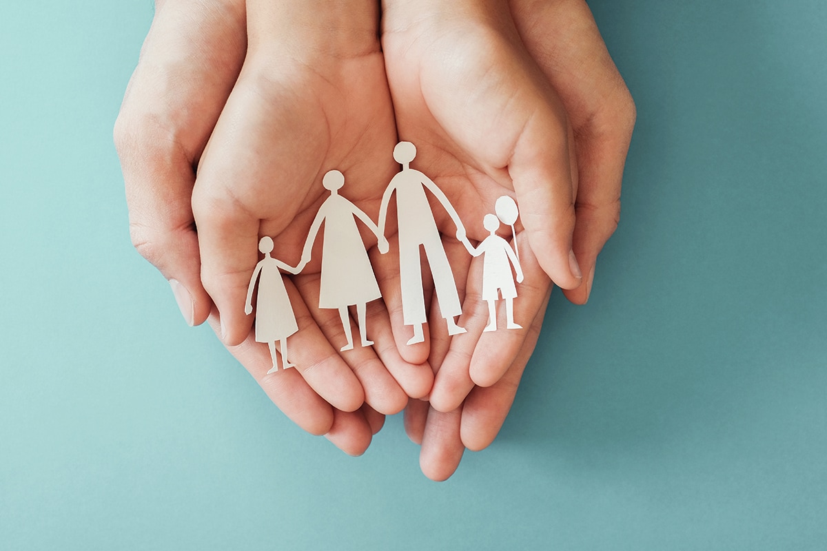 Paper cut outs of a family holding hands on a blue background with the keyword "التغلب على التشبه بالنساء.