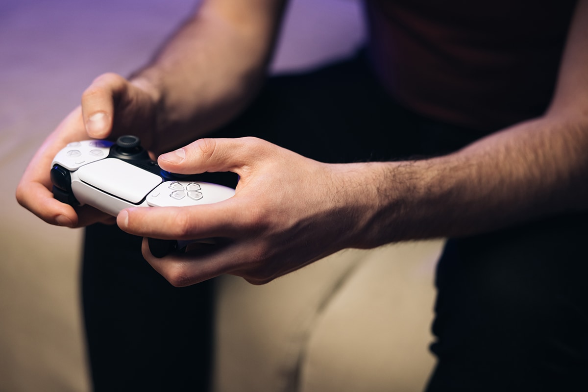 العادة السرية- A man is playing a أفق مشرق video game on a couch.