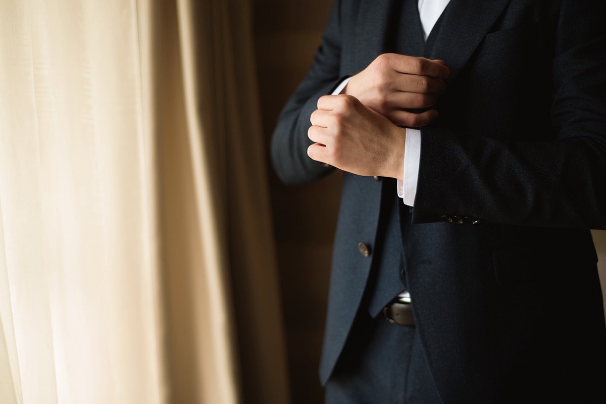 الوهم والقلق A man in a suit is adjusting his tie during sunrise.