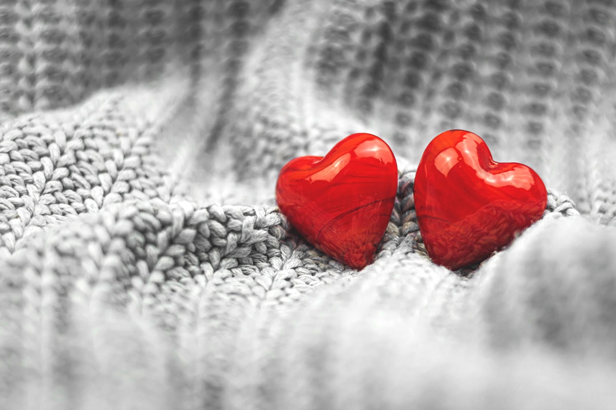 عودة الثقة بالنفس -Two red hearts resting on a gray sweater, evoking intense fear since childhood.