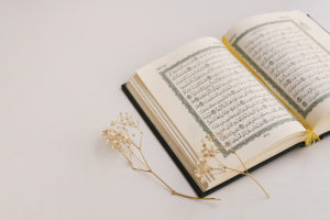 An open Muslim Quran on a white background, expressing مودة ورحمة (love and mercy) in contrast to خوف وقلق (fear and anxiety).