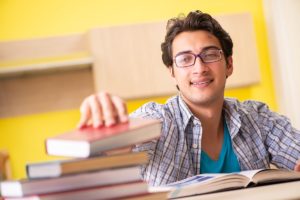 القلق من الامتحان -A man experiencing a new dawn after intense distress, sitting at a table surrounded by books.