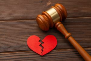 آخر الدواء الافتراق-A broken heart and a gavel on a wooden table symbolize the pain of separation.