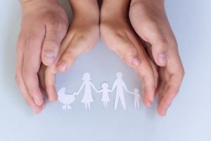 A family showing support and building trust with a paper cut out.