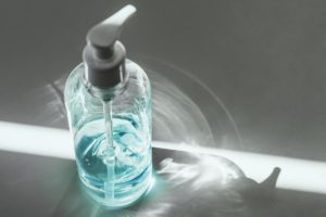 وسواس الجراثيم-A bottle of hand sanitizer eliminates germs on a white surface with determination.