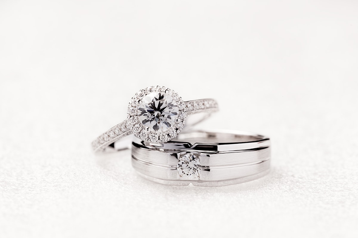 قرار زواج خاطئ-Two engagement rings on a white surface symbolizing the fateful decision of marriage.